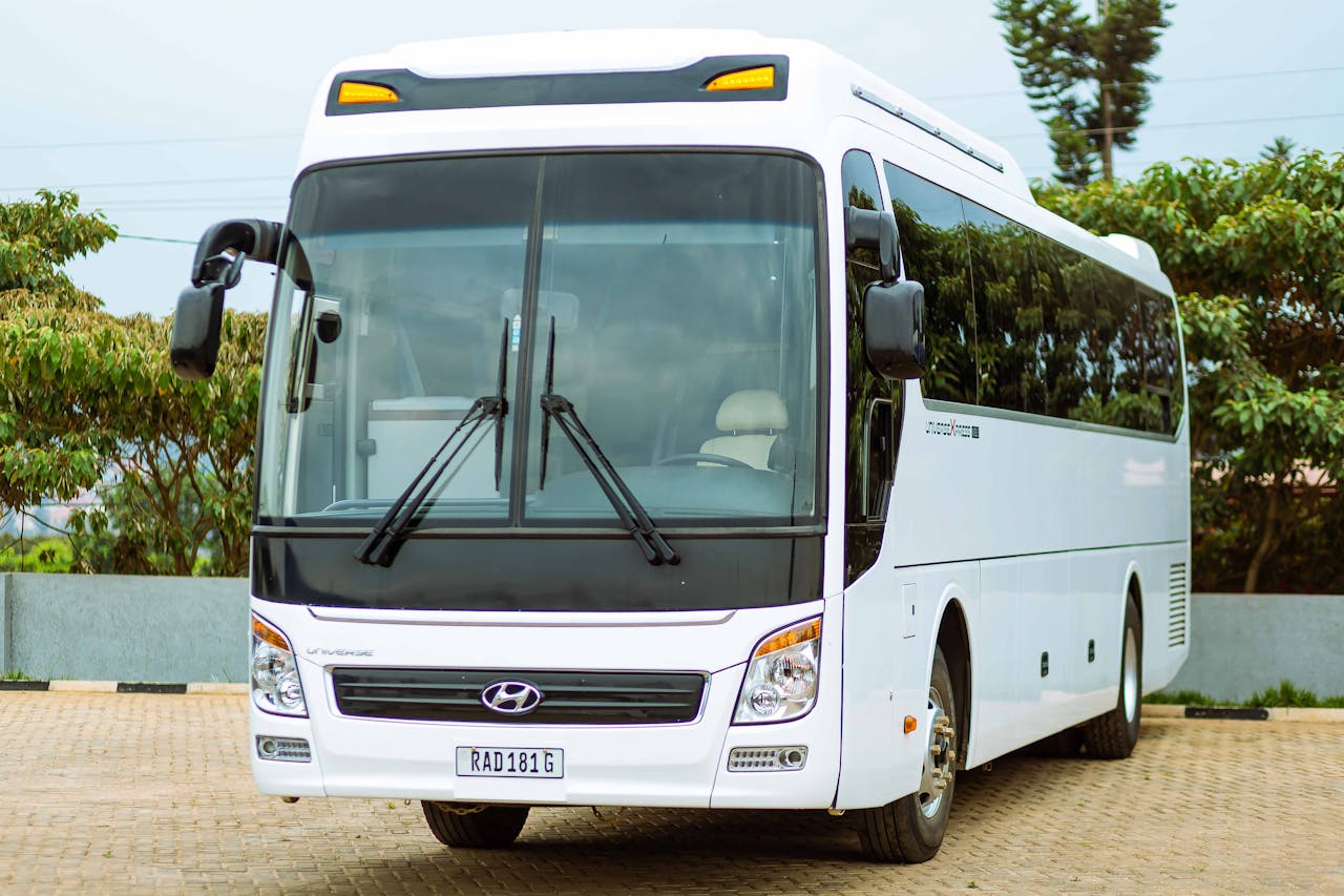 Front view of a modern white bus parked in an outdoor setting.