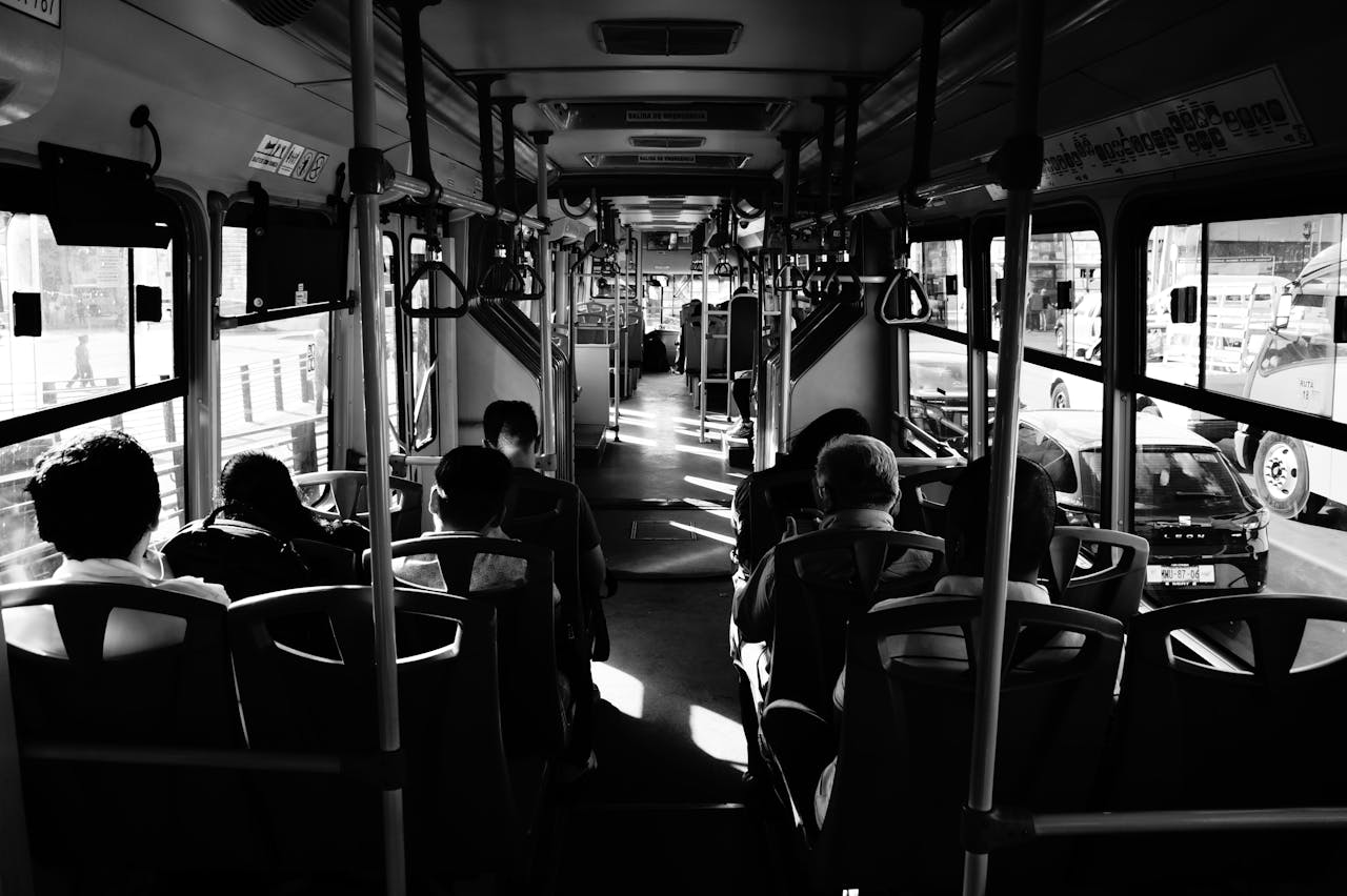 A monochromatic view of passengers inside a moving bus in Mexico City.